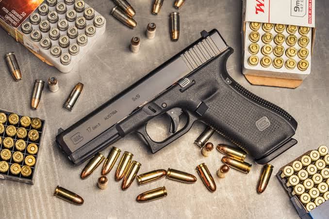 Pistola, carregadores e munições sobre mesa